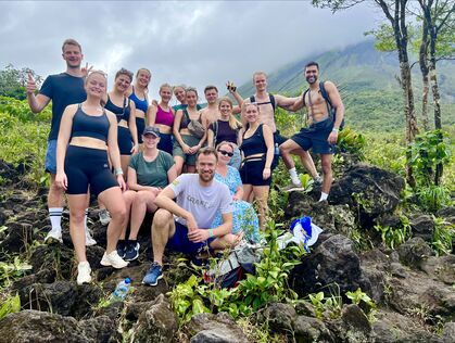 Grupp vid vulkanen Arenal i bakgrunden i Costa Rica